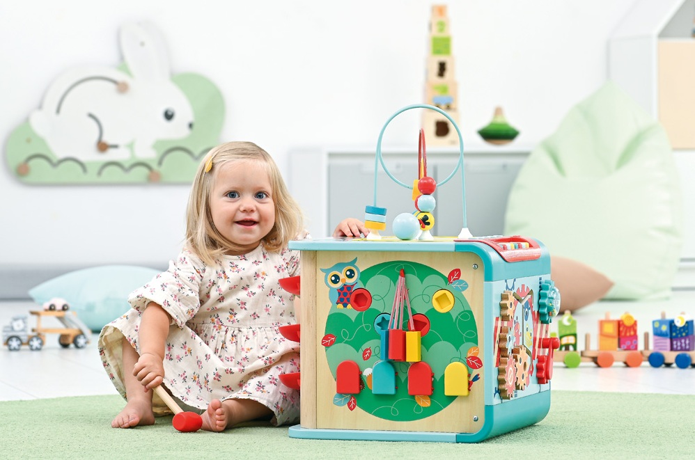 Dziewczynka bawiąca się kostka maniuplacyjną w żłobku